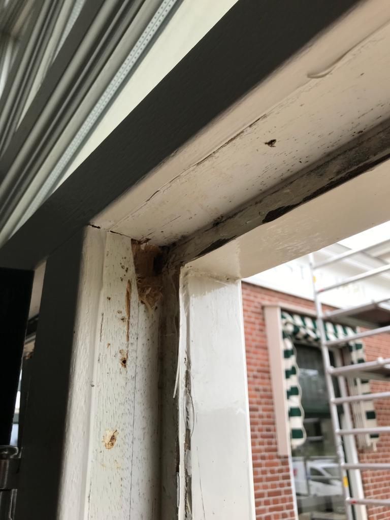 Houtrot blootgelegd bij hoek en dorpel van een raamkozijn